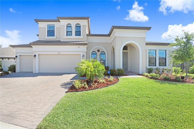 mediterranean / spanish-style house featuring a front yard and a garage