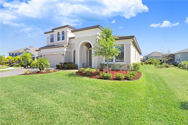 mediterranean / spanish house featuring a garage and a front yard