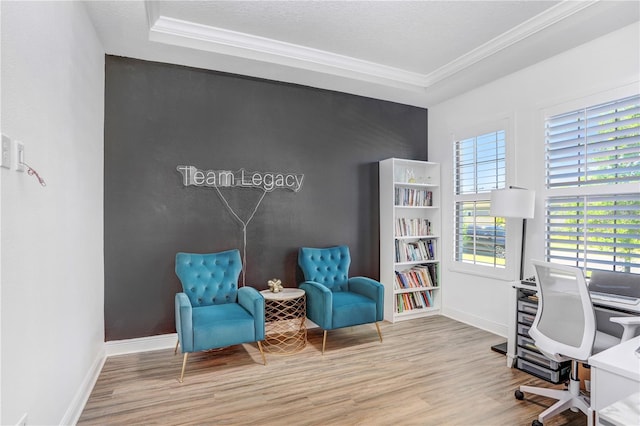 office area with plenty of natural light, ornamental molding, light hardwood / wood-style flooring, and a raised ceiling