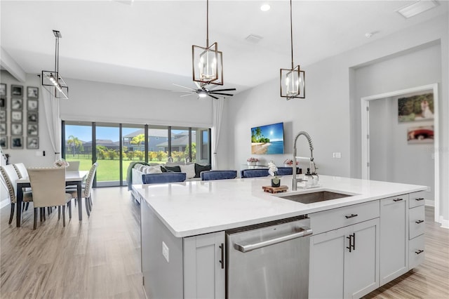 kitchen with white cabinets, a kitchen island with sink, pendant lighting, sink, and dishwasher