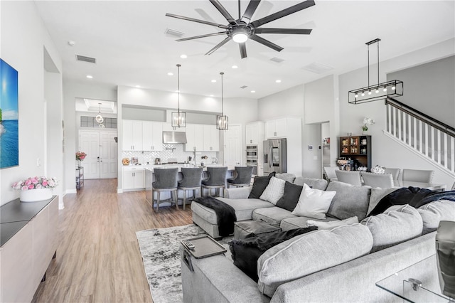 living room with ceiling fan and light hardwood / wood-style flooring