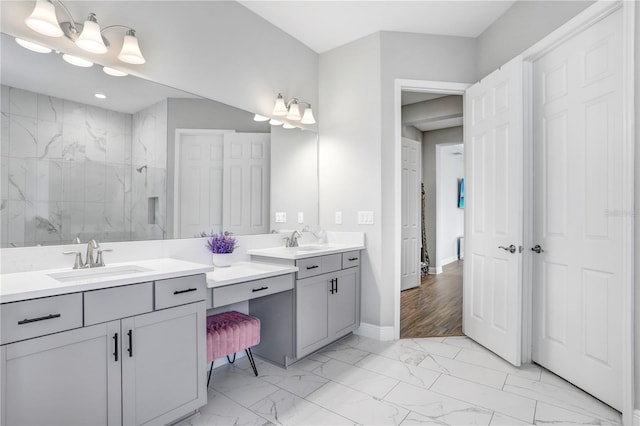 bathroom featuring a tile shower, double sink vanity, and hardwood / wood-style floors