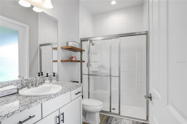 bathroom featuring walk in shower, vanity, and toilet