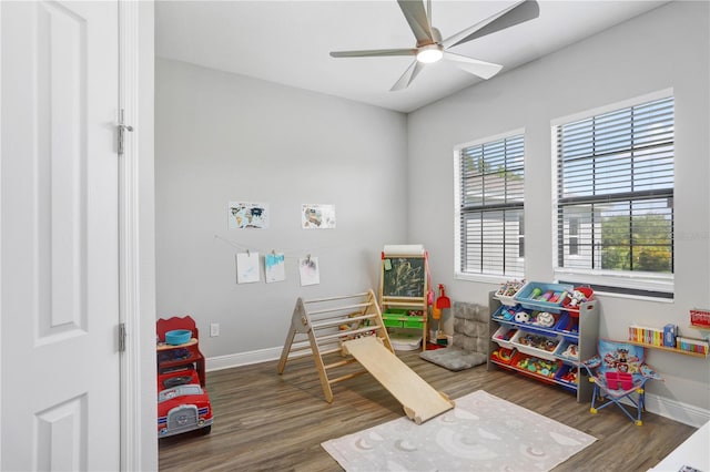 playroom with dark wood-type flooring and ceiling fan