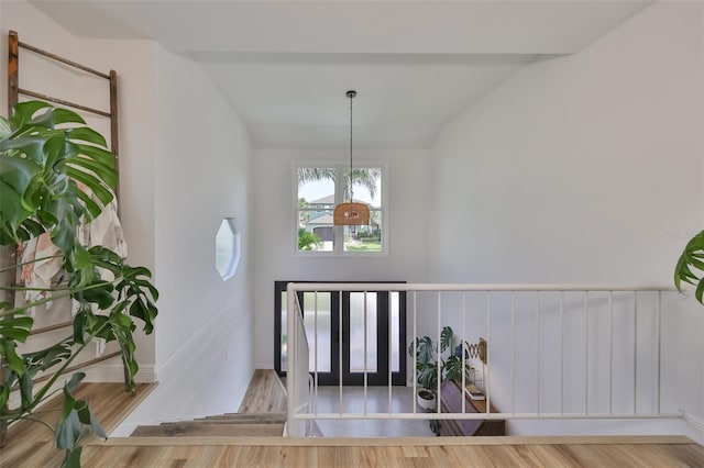 foyer with a notable chandelier, vaulted ceiling, and wood-type flooring