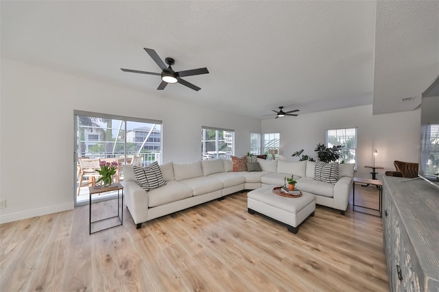 living room with a wealth of natural light, ceiling fan, and light wood-type flooring