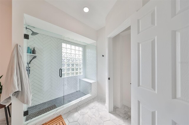 bathroom with an enclosed shower and tile floors