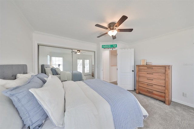 carpeted bedroom with ceiling fan, a closet, and ornamental molding