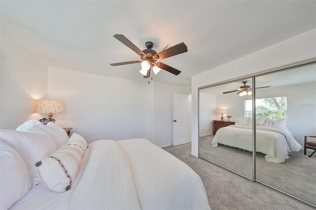 bedroom featuring ceiling fan, a closet, and carpet flooring