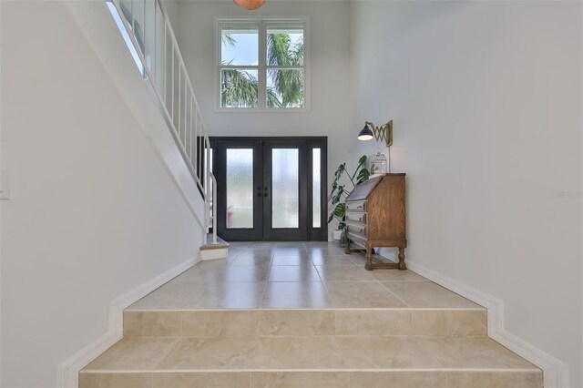 foyer with a towering ceiling and french doors