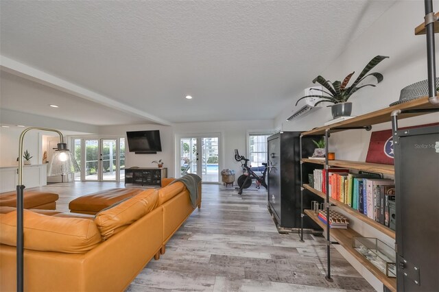 living room featuring a textured ceiling, wood-type flooring, and french doors