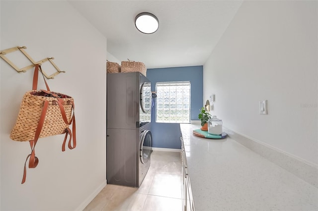 washroom with light tile floors and stacked washer / drying machine