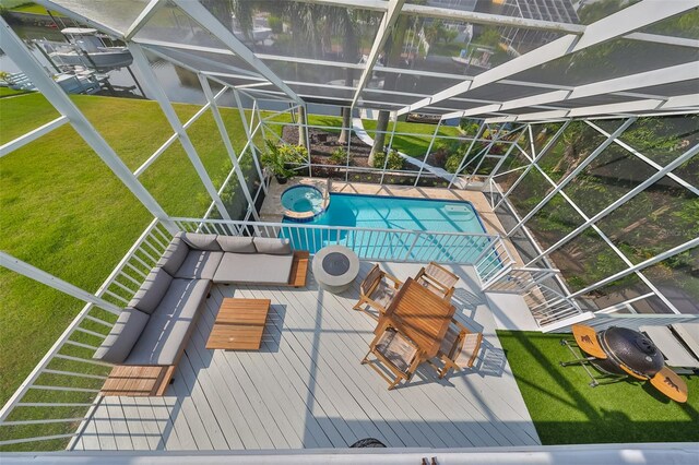 view of pool featuring glass enclosure and a lawn