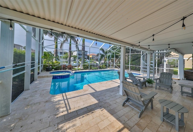 view of pool with a patio, a lanai, and an in ground hot tub