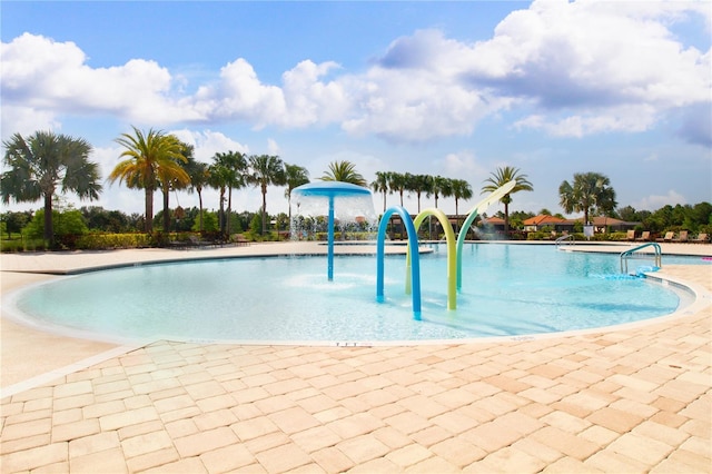 view of swimming pool with pool water feature and a patio