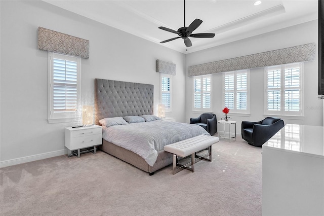 bedroom featuring a tray ceiling, ceiling fan, crown molding, and carpet