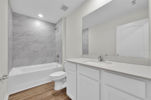 full bathroom featuring tiled shower / bath combo, wood-type flooring, vanity, and toilet