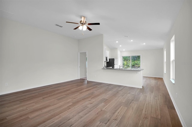 unfurnished living room featuring wood-type flooring and ceiling fan