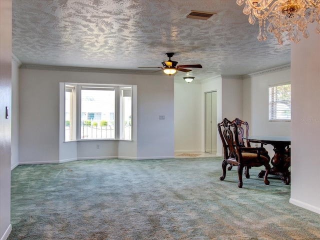 interior space featuring carpet, ceiling fan, a textured ceiling, and crown molding