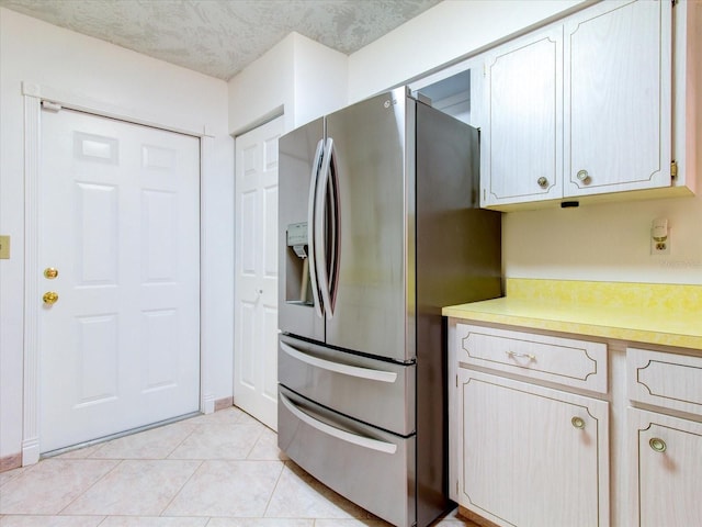 kitchen with stainless steel fridge and light tile floors