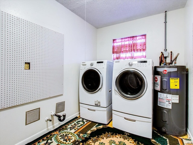 laundry area with washer and dryer, a textured ceiling, and electric water heater