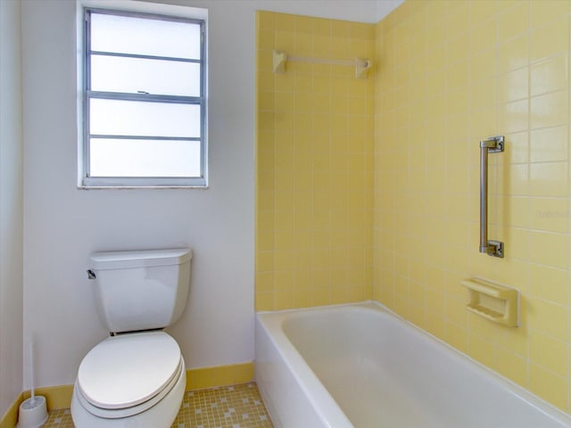 bathroom featuring tile flooring, toilet, and tiled shower / bath combo