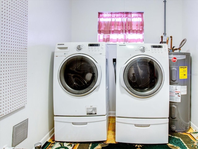 clothes washing area with independent washer and dryer and water heater