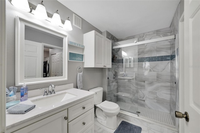 bathroom with an enclosed shower, tile floors, washer / clothes dryer, toilet, and vanity