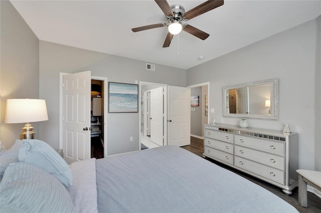 bedroom featuring ceiling fan, ensuite bathroom, and dark wood-type flooring