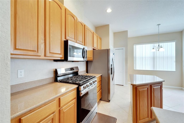 kitchen featuring tasteful backsplash, stainless steel appliances, light tile flooring, pendant lighting, and a notable chandelier