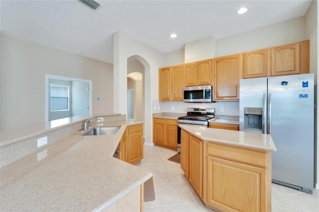 kitchen featuring light stone counters, backsplash, light tile floors, sink, and appliances with stainless steel finishes