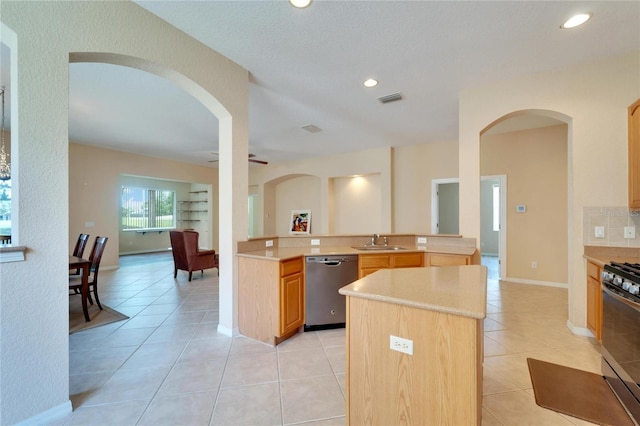 kitchen featuring a kitchen island, stainless steel appliances, sink, ceiling fan, and light tile floors