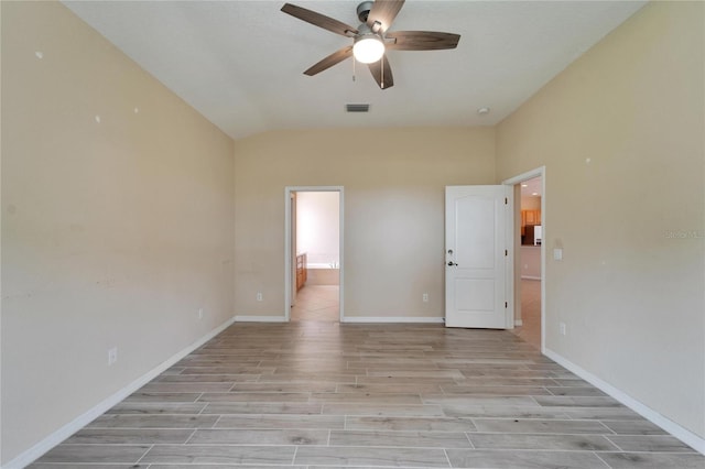 interior space with light wood-type flooring, ceiling fan, and ensuite bath