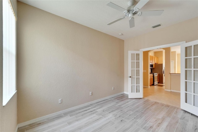 spare room with light tile flooring, ceiling fan, and french doors