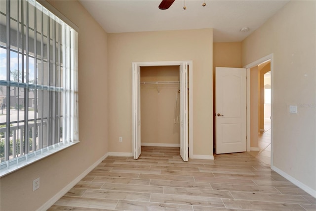 unfurnished bedroom featuring light hardwood / wood-style floors, a closet, and ceiling fan