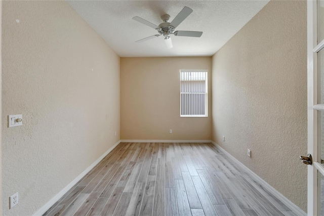 empty room featuring a textured ceiling, ceiling fan, and light wood-type flooring