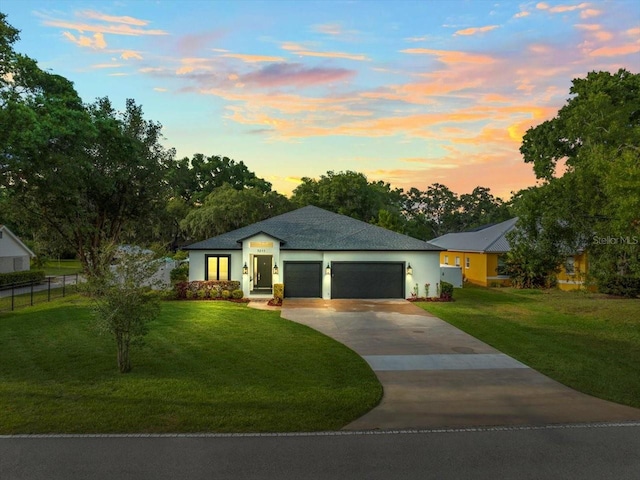 view of front of home with a garage and a yard