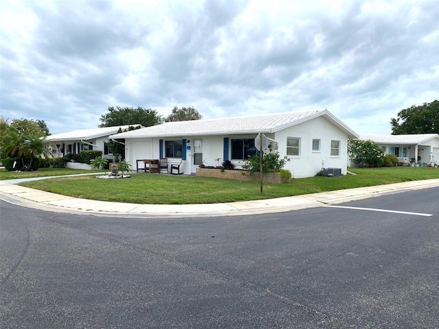 ranch-style home featuring central AC and a front lawn