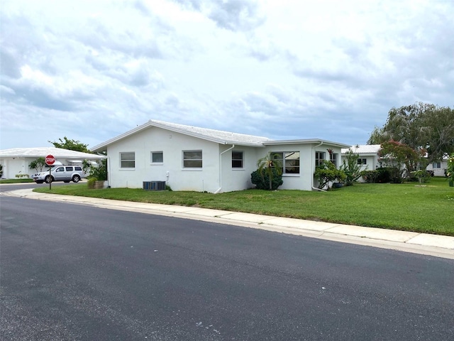 ranch-style home with central AC and a front yard