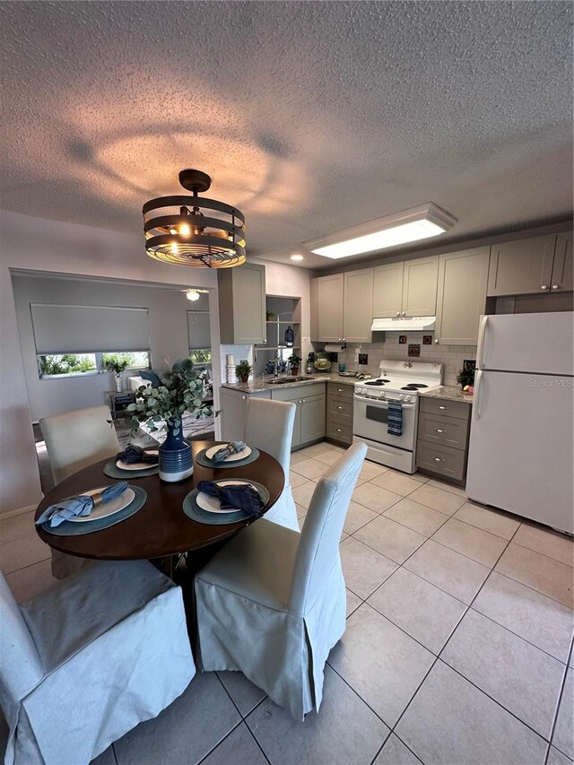 tiled dining space featuring a textured ceiling and sink