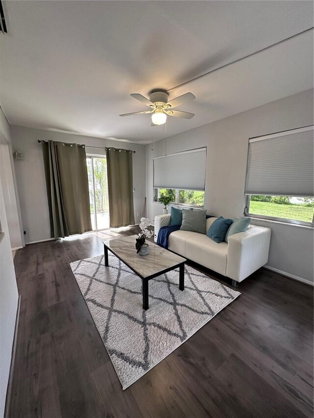 living room featuring ceiling fan and dark hardwood / wood-style floors