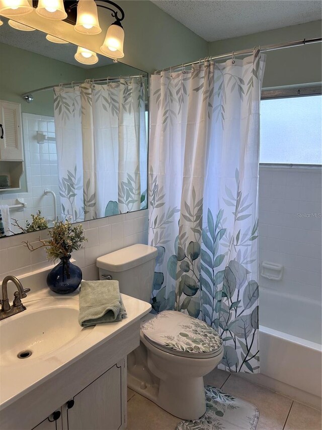 full bathroom with vanity, a textured ceiling, shower / bath combo, toilet, and tile patterned floors