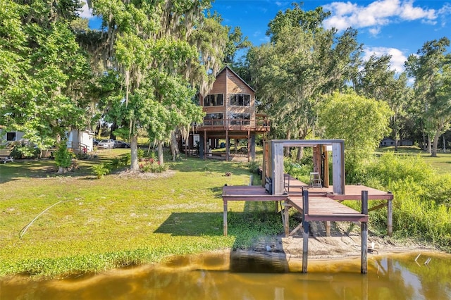 back of property featuring a yard and a deck with water view