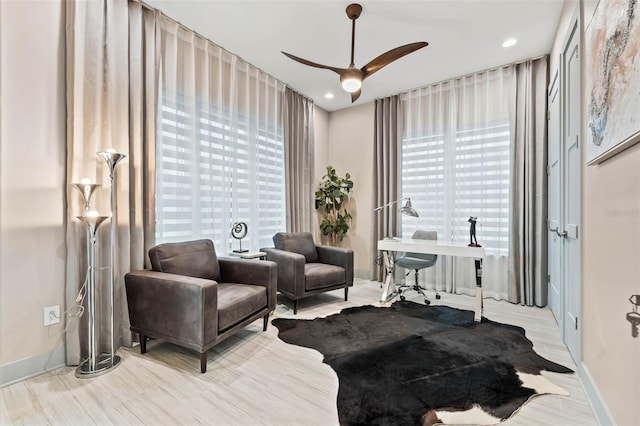 living area featuring light wood-type flooring and ceiling fan