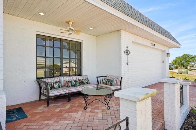 view of patio / terrace with a garage, an outdoor living space, and a ceiling fan