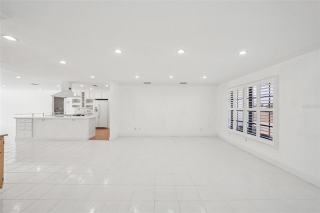 unfurnished living room with recessed lighting and baseboards