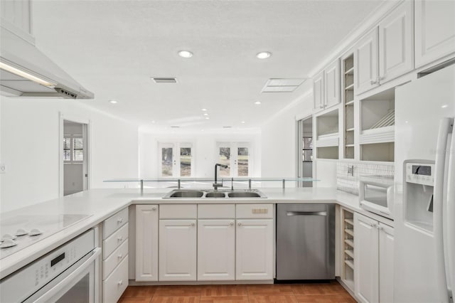 kitchen with light countertops, white appliances, white cabinets, and a sink