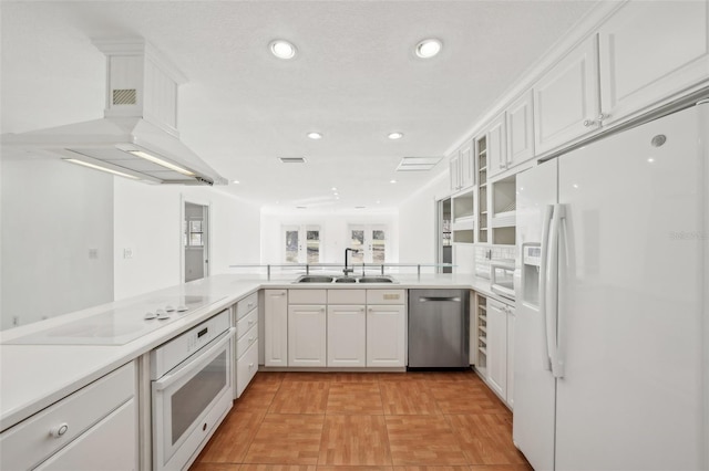 kitchen featuring white appliances, light countertops, a sink, and white cabinetry