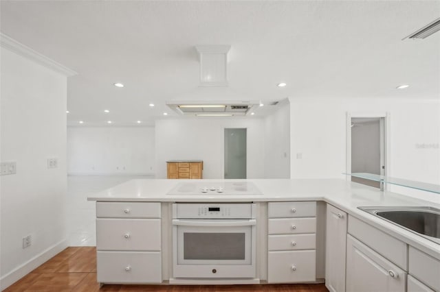 kitchen with recessed lighting, white appliances, visible vents, white cabinetry, and light countertops