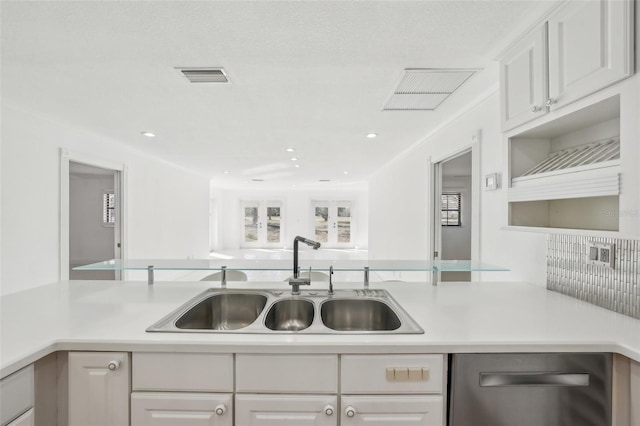 kitchen featuring light countertops, a sink, visible vents, and white cabinetry